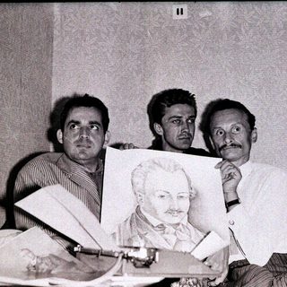Three men holding a portrait of Lenin indoors.