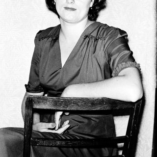 Woman in 1930s-40s style dress posing indoors.