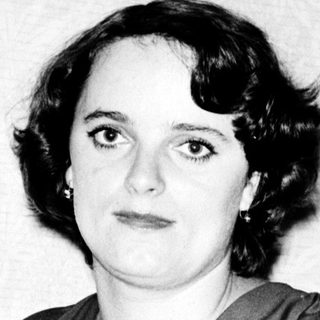 Woman in 1930s-40s style dress posing indoors.