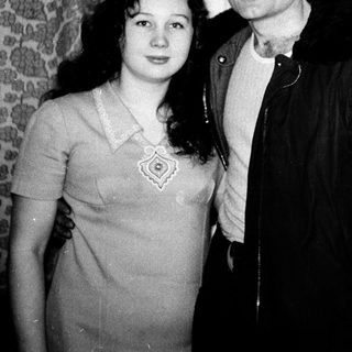 Two people posing closely indoors, mid-20th century style.