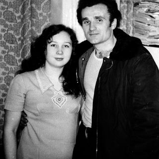 Two people posing closely indoors, mid-20th century style.