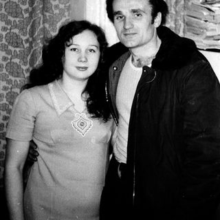 Two people posing closely indoors, mid-20th century style.