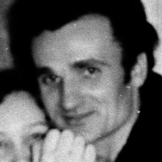 A couple hugging indoors, mid-20th century.