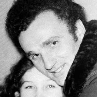 Two people hugging affectionately indoors.