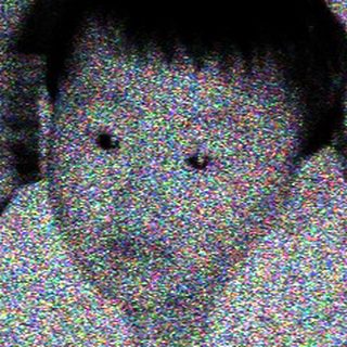 Child lying on bed, holding toy.