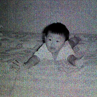 Child lying on bed, holding toy.