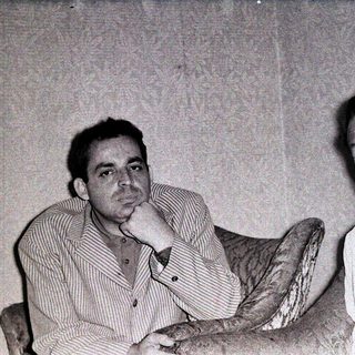 Two men in vintage attire posing together.
