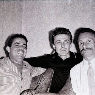 Three men posing together in vintage style.