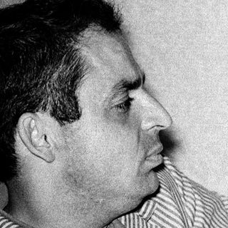 Man in striped shirt posing indoors.