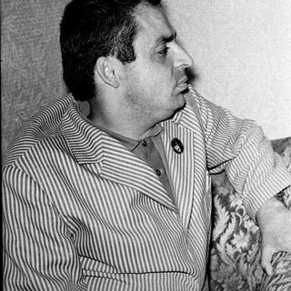 Man in striped shirt posing indoors.