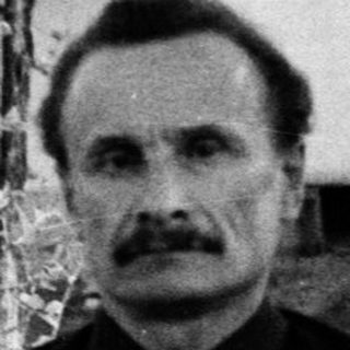 Man sitting outdoors in vintage black-and-white photograph.