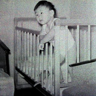 Baby sitting in a crib.