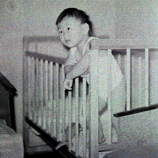 Baby sitting in a crib.