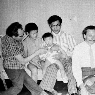 Family gathering with adults and a baby indoors.