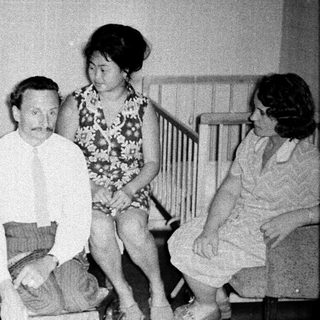 Family gathering with adults and a baby indoors.