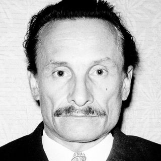 Portrait of an older man in formal attire with mustache.