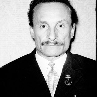 Portrait of an older man in formal attire with mustache.