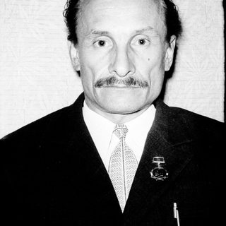 Portrait of an older man in formal attire with mustache.