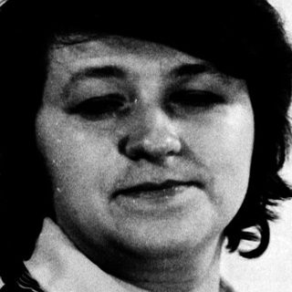 Portrait of a person in a vest and blouse.