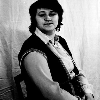 Portrait of a person in a vest and blouse.
