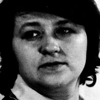 Portrait of a person in a vest and blouse.