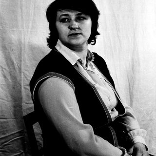 Portrait of a person in a vest and blouse.