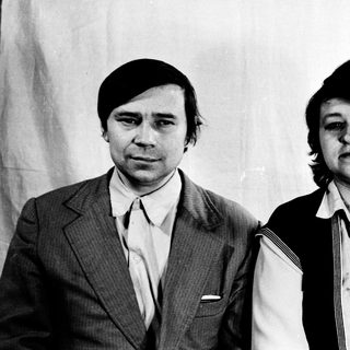 Two individuals in 1970s-style formal attire posing together.
