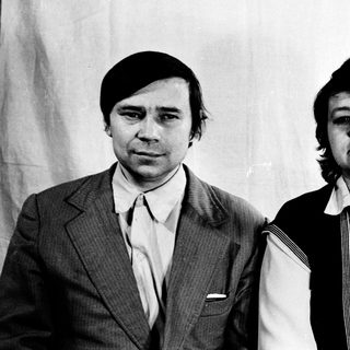 Two individuals in 1970s-style formal attire posing together.