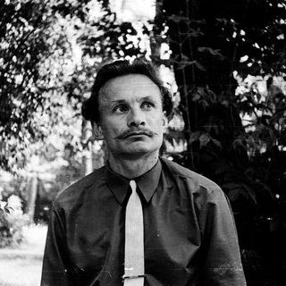 Man in formal attire standing outdoors.