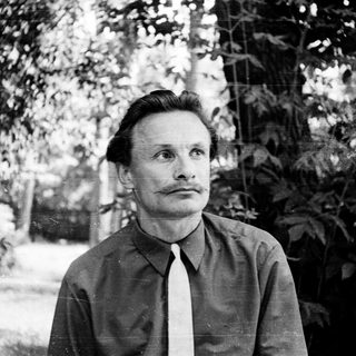 Man in outdoor setting, mid-century black-and-white portrait.
