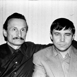 Two men posing together in a candid, vintage-style photograph.