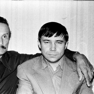 Two men posing together in a candid, vintage-style photograph.