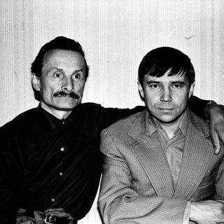 Two men posing together in a candid black-and-white photo.
