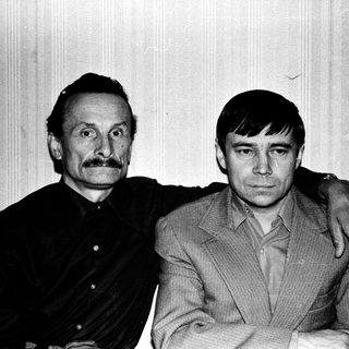 Two men posing together in a vintage photograph.