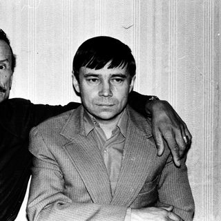 Two men posing together in a vintage photograph.