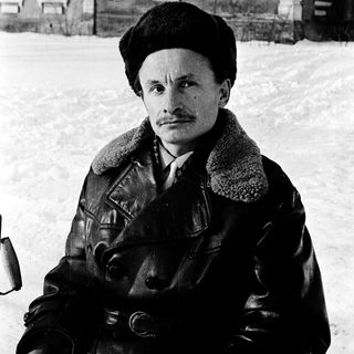 Man in winter attire posing outdoors in snowy setting.