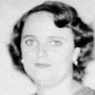 Black-and-white portrait of woman seated on chair.