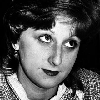 Black-and-white portrait of a woman indoors.