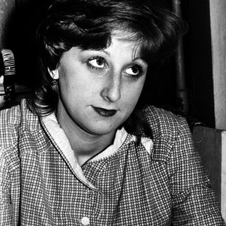 Black-and-white portrait of a woman indoors.