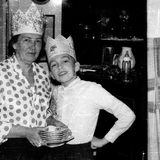 A woman and child dressed as chefs holding plates.