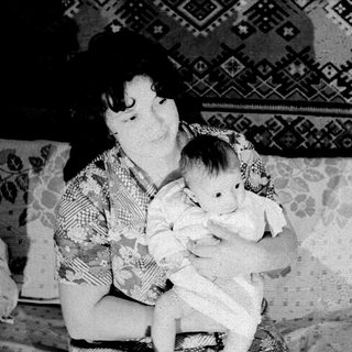 A woman holding a baby indoors.