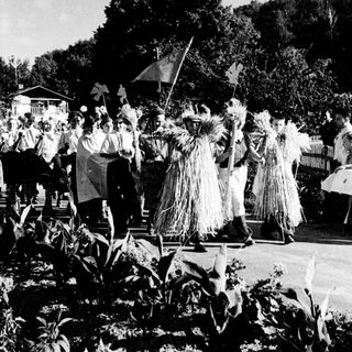 Traditional festival dancers in elaborate straw costumes.