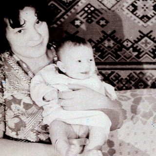 A woman holding a baby indoors.