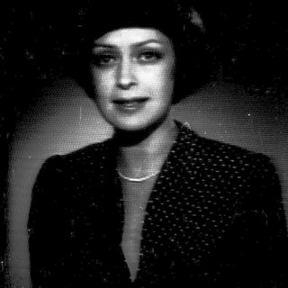 Vintage portrait of a woman in 1940s-style attire.