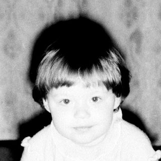 Baby crawling on patterned carpet indoors.