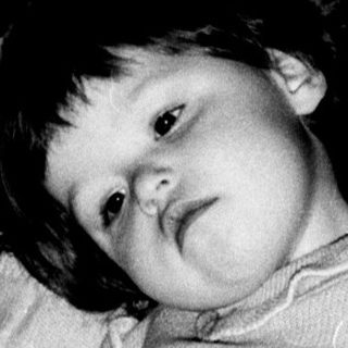 Young child reading book indoors.
