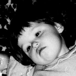 Young child reading book indoors.