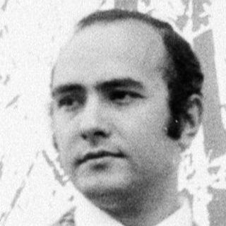 Man in plaid suit, standing indoors.