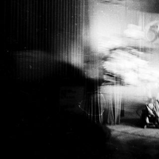 Blurred stage scene with crowd and blurred performer.