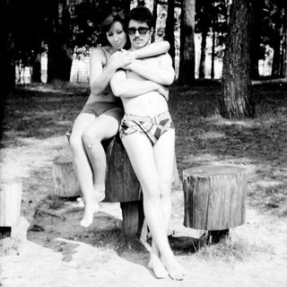 Two people hugging outdoors in swimwear.